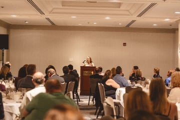 A person standing at a podium with a crowd of people sitting around
AI-generated content may be incorrect., Picture